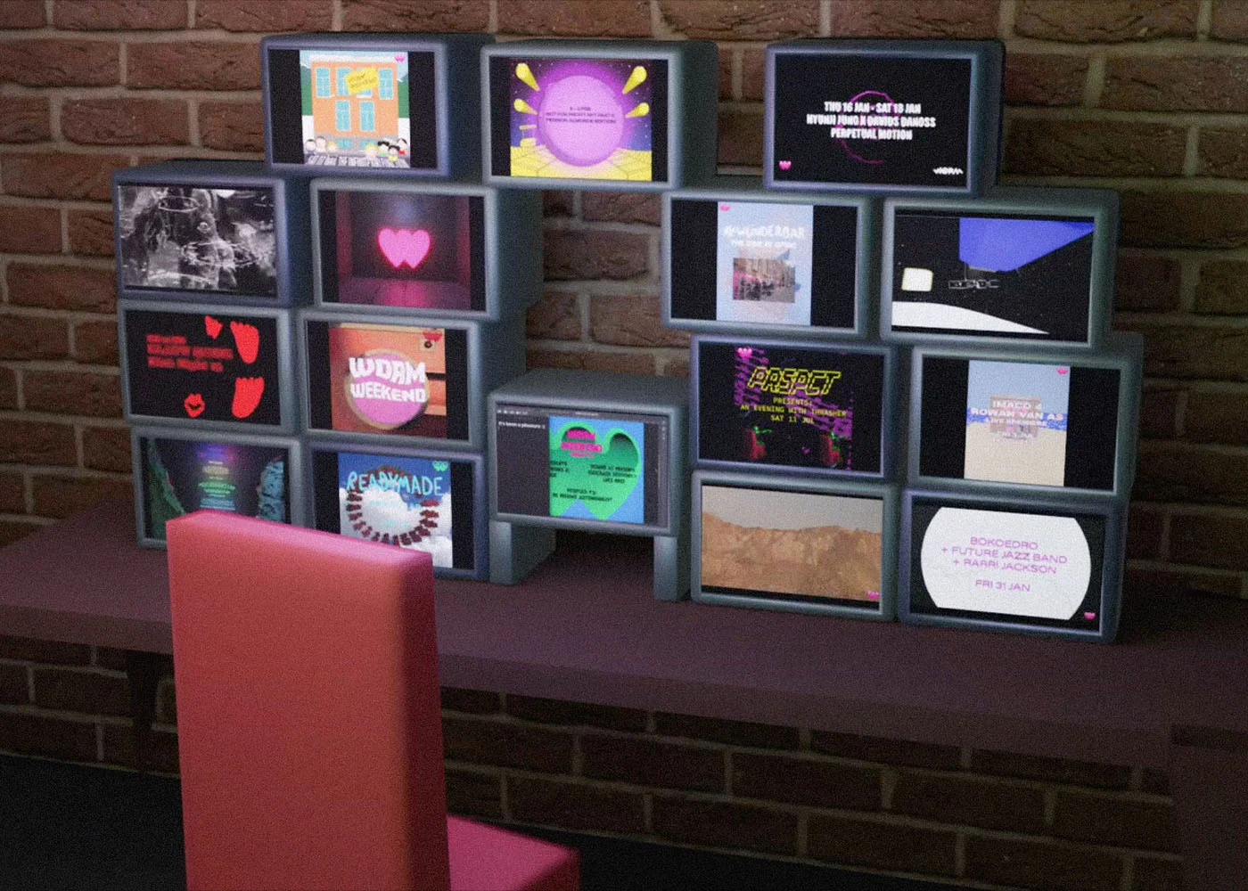 3D Render. Desk filled with old screens, each showing a different WORM Weekend video.