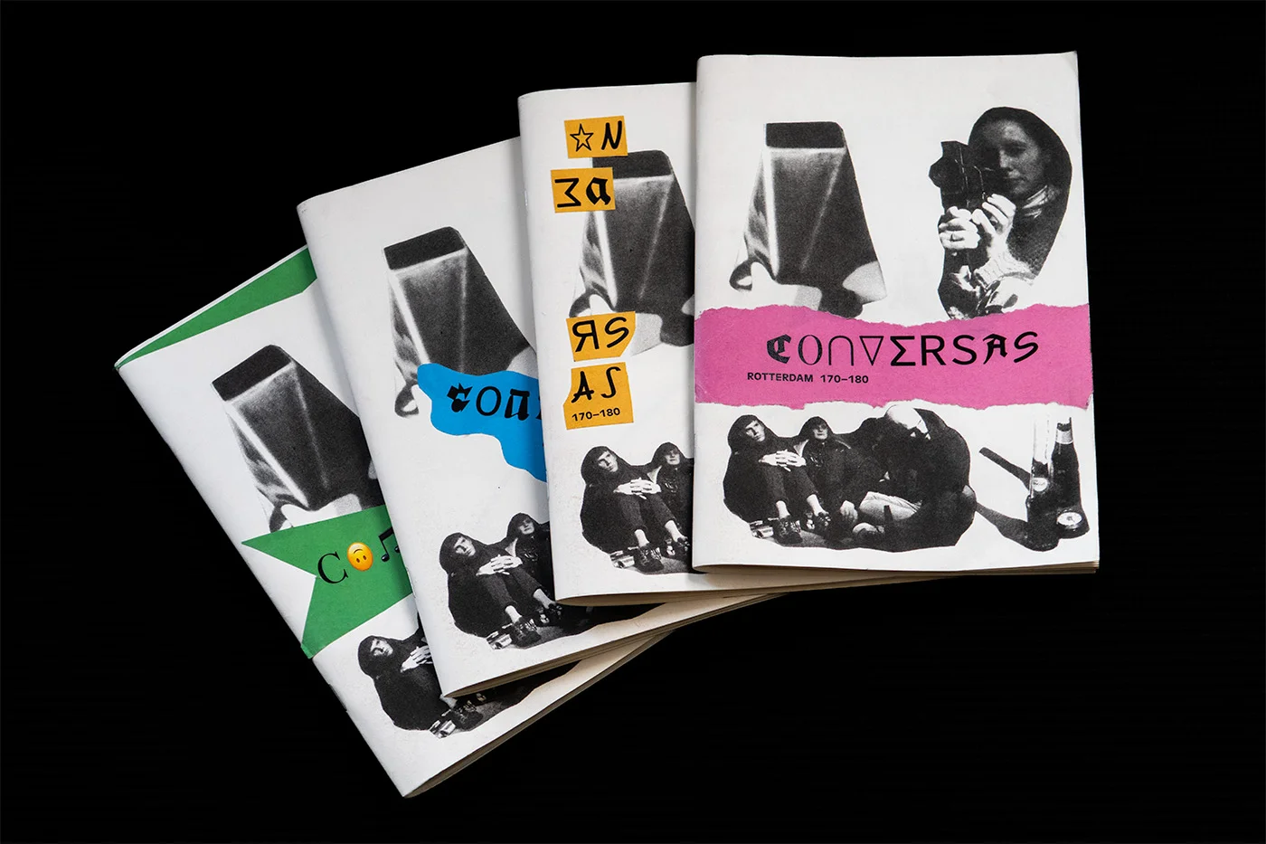 Stack of four identical black and white A5 magazines, each decorated with differently coloured stickers.